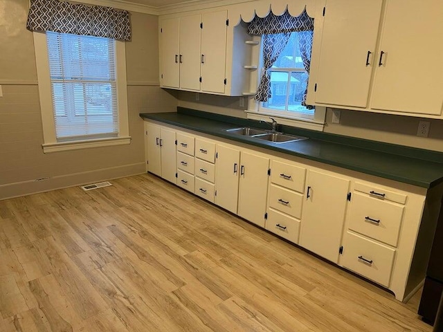 7 S Grove St, Waterville, ME 04901 - kitchen with dark countertops, white cabinets, light wood-style flooring, and crown molding
