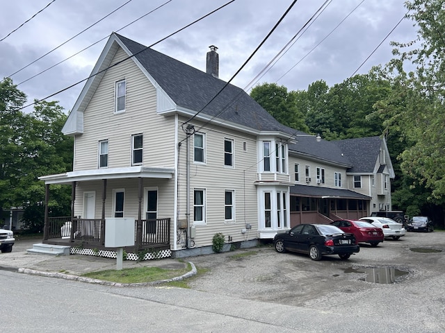 17 Autumn St, Gardiner, ME 04345 - view of front of property with a porch, a chimney, a shingled roof, and uncovered parking