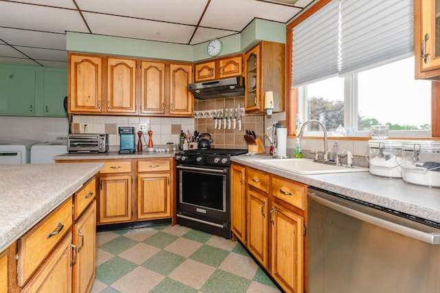 2887 Middle Rd, Sidney, ME 04330 - kitchen featuring dishwasher, black gas range, washer and dryer, under cabinet range hood, and dark flooring