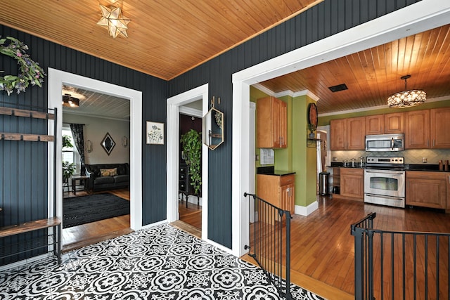 4 Hillcrest St, Waterville, ME 04901 - kitchen with stainless steel appliances, crown molding, dark countertops, decorative backsplash, and brown cabinets