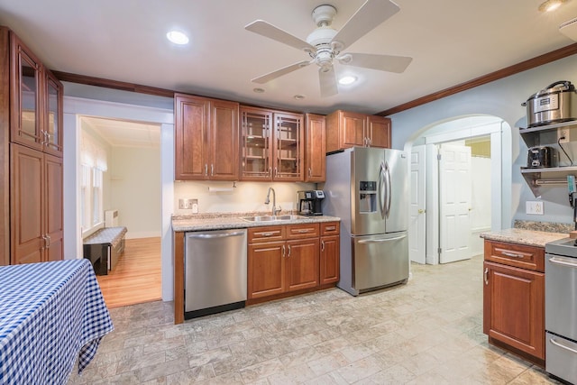 3 N Garand St, Winslow, ME 04901 - kitchen with appliances with stainless steel finishes, crown molding, ceiling fan, light stone counters, and brown cabinetry