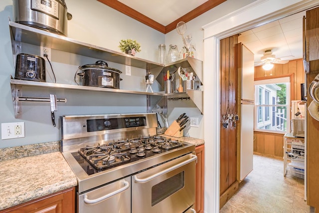 3 N Garand St, Winslow, ME 04901 - kitchen featuring stainless steel range with gas cooktop, a ceiling fan, crown molding, brown cabinets, and light stone countertops