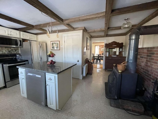 38 Atkinson Rd, Charleston, ME 04422 - kitchen featuring stainless steel appliances, coffered ceiling, a wood stove, white cabinetry, and dark stone countertops