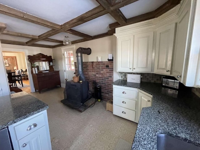 38 Atkinson Rd, Charleston, ME 04422 - kitchen with coffered ceiling, a wood stove, white cabinetry, beam ceiling, and dark stone countertops
