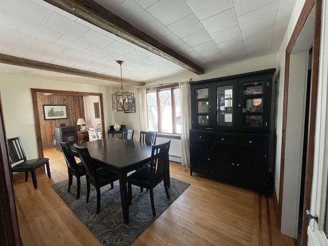 38 Atkinson Rd, Charleston, ME 04422 - dining area with light wood-style floors, a chandelier, a baseboard heating unit, and beam ceiling
