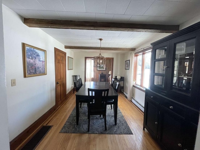 38 Atkinson Rd, Charleston, ME 04422 - dining space with beamed ceiling, plenty of natural light, light wood-style flooring, a chandelier, and a baseboard heating unit