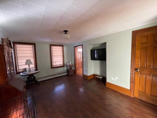 38 Atkinson Rd, Charleston, ME 04422 - unfurnished living room featuring baseboard heating and wood finished floors
