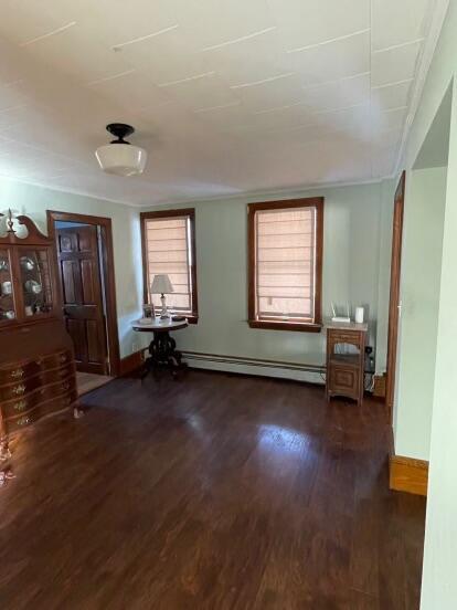 38 Atkinson Rd, Charleston, ME 04422 - unfurnished room featuring a baseboard heating unit and dark wood-style flooring