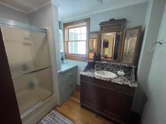 38 Atkinson Rd, Charleston, ME 04422 - full bath featuring ornamental molding, an enclosed shower, vanity, and wood finished floors