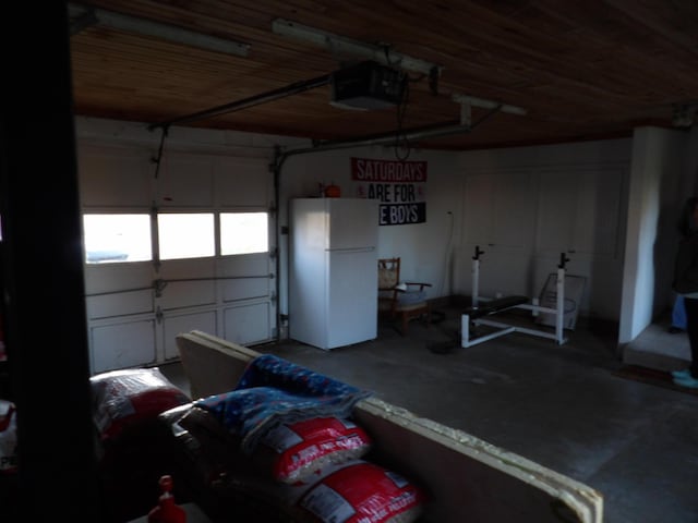 38 Atkinson Rd, Charleston, ME 04422 - garage featuring freestanding refrigerator and a garage door opener