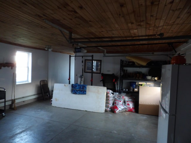 38 Atkinson Rd, Charleston, ME 04422 - basement featuring freestanding refrigerator, a garage, and wooden ceiling