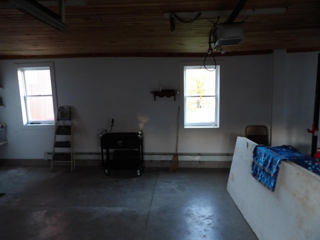 38 Atkinson Rd, Charleston, ME 04422 - garage with a garage door opener, wooden ceiling, and a baseboard radiator