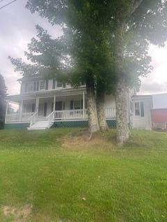38 Atkinson Rd, Charleston, ME 04422 - view of front of house featuring a porch and a front yard