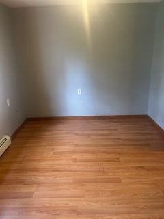 38 Atkinson Rd, Charleston, ME 04422 - empty room featuring light wood finished floors and a baseboard heating unit
