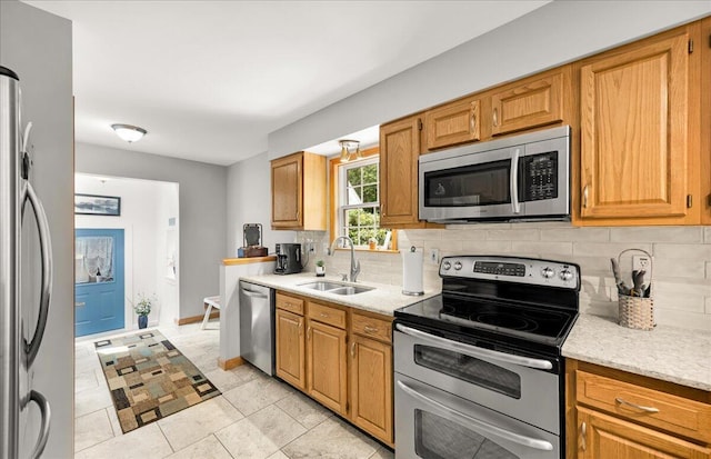 21 Bowling Green Ln, Belfast, ME 04915 - kitchen with stainless steel appliances, tasteful backsplash, light tile patterned floors, and brown cabinets
