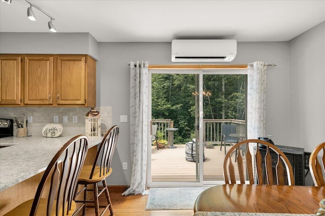 21 Bowling Green Ln, Belfast, ME 04915 - dining room featuring a wall unit AC, light wood-style floors, and track lighting