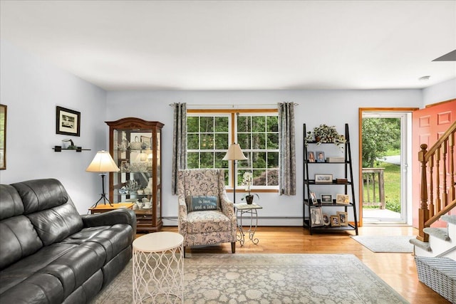 21 Bowling Green Ln, Belfast, ME 04915 - living area featuring a baseboard heating unit, stairs, wood finished floors, and healthy amount of natural light