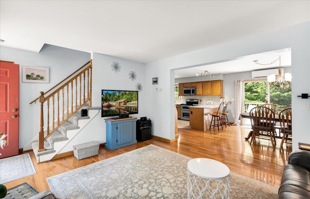 21 Bowling Green Ln, Belfast, ME 04915 - living area with light wood finished floors, a chandelier, and stairs