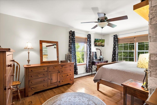 21 Bowling Green Ln, Belfast, ME 04915 - bedroom featuring a baseboard radiator, light wood-style flooring, and a ceiling fan