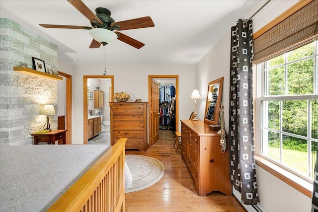 21 Bowling Green Ln, Belfast, ME 04915 - bedroom featuring light wood-style floors, a walk in closet, ensuite bathroom, and a ceiling fan