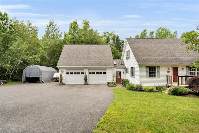 21 Bowling Green Ln, Belfast, ME 04915 - view of front of house featuring an attached garage, a front yard, roof with shingles, and driveway
