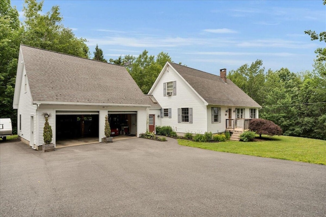 21 Bowling Green Ln, Belfast, ME 04915 - view of front of home featuring a chimney, asphalt driveway, roof with shingles, and a garage