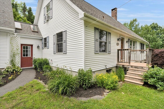 21 Bowling Green Ln, Belfast, ME 04915 - view of side of home featuring a chimney, a deck, a lawn, and roof with shingles