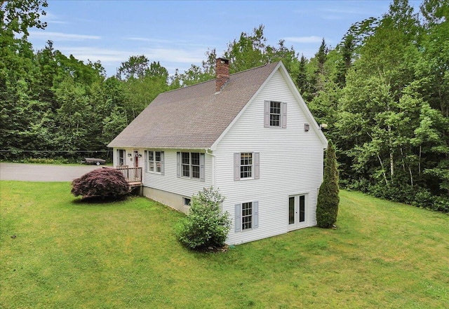 21 Bowling Green Ln, Belfast, ME 04915 - view of home's exterior with a chimney, a lawn, and a shingled roof