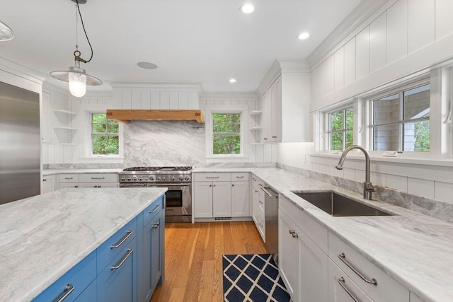 17 Intervale Rd, York, ME 03902 - kitchen with appliances with stainless steel finishes, blue cabinetry, open shelves, white cabinetry, and tasteful backsplash