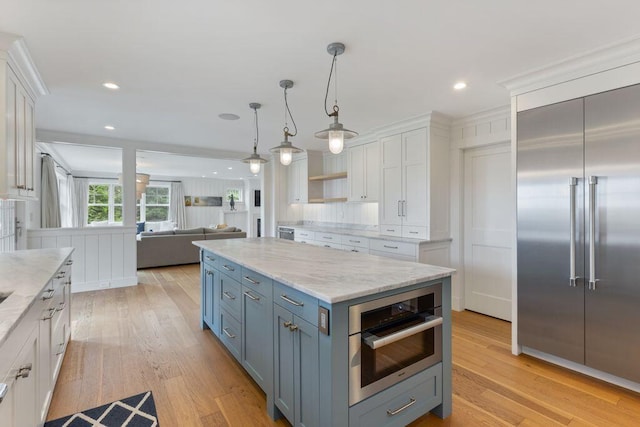 17 Intervale Rd, York, ME 03902 - kitchen with built in fridge, white cabinets, light wood finished floors, open floor plan, and light stone countertops