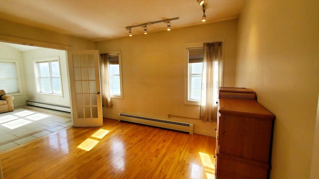 9 Wood St, Bangor, ME 04401 - empty room with a baseboard heating unit, light wood-type flooring, and rail lighting