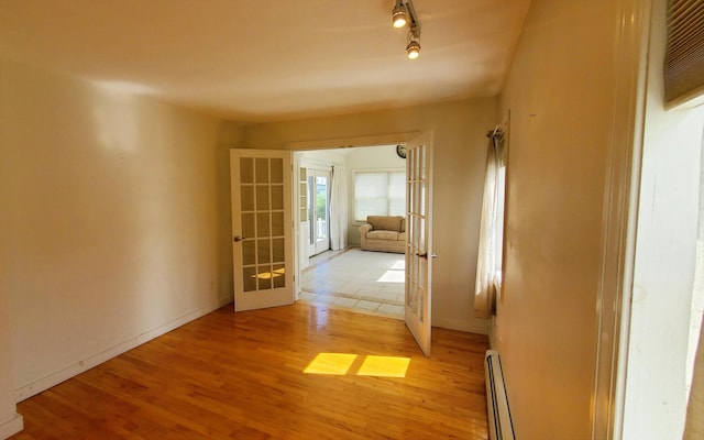 9 Wood St, Bangor, ME 04401 - hallway with french doors, baseboard heating, light wood-style flooring, and rail lighting