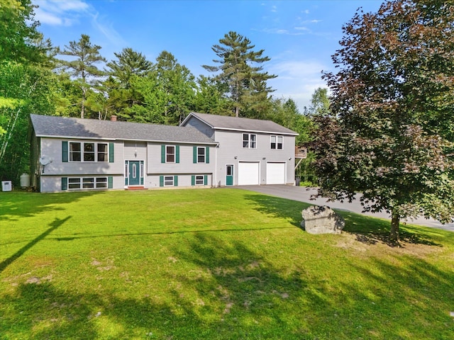 2 Bryer Heights Rd, Milford, ME 04461 - split foyer home featuring a garage, asphalt driveway, a front yard, and a chimney