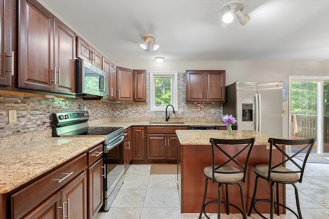 2 Bryer Heights Rd, Milford, ME 04461 - kitchen featuring appliances with stainless steel finishes, a kitchen bar, tasteful backsplash, and healthy amount of natural light