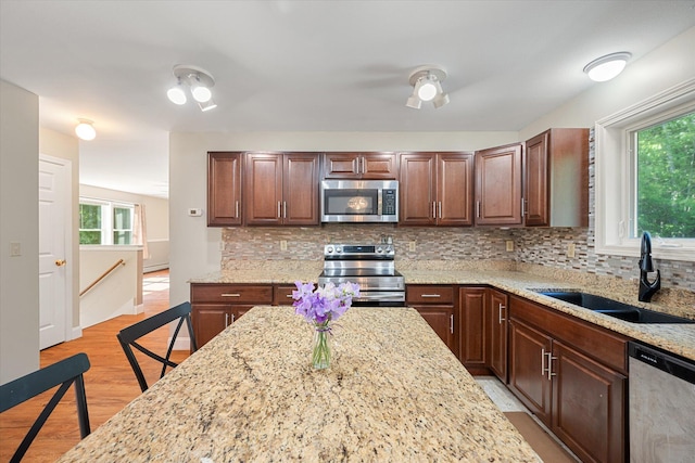 2 Bryer Heights Rd, Milford, ME 04461 - kitchen featuring appliances with stainless steel finishes, healthy amount of natural light, light wood-style floors, and backsplash