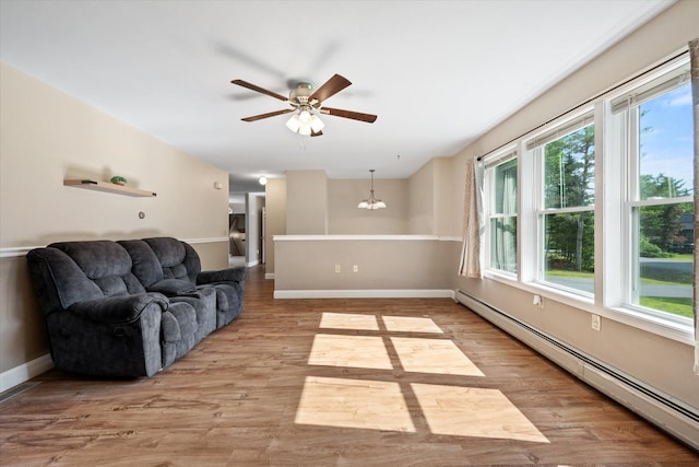 2 Bryer Heights Rd, Milford, ME 04461 - living area featuring a baseboard heating unit, plenty of natural light, ceiling fan, and wood finished floors