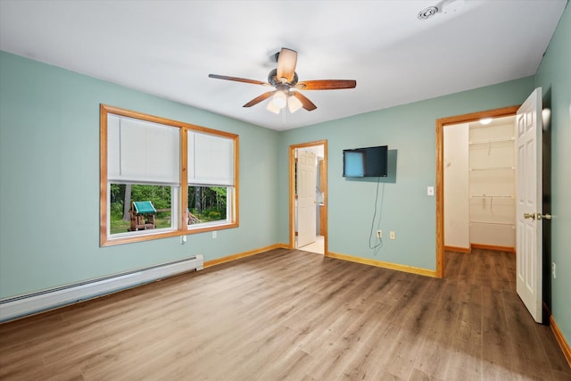 2 Bryer Heights Rd, Milford, ME 04461 - unfurnished bedroom featuring baseboard heating, wood finished floors, and ceiling fan