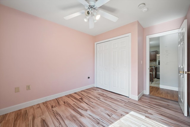 2 Bryer Heights Rd, Milford, ME 04461 - unfurnished bedroom with light wood finished floors, a closet, stainless steel fridge, and a ceiling fan