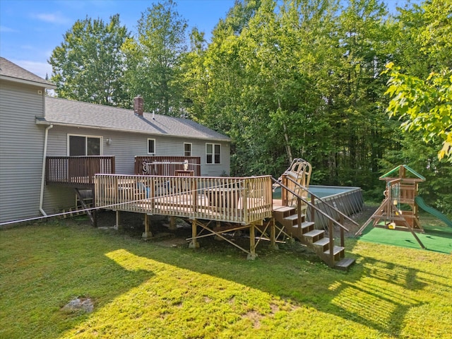 2 Bryer Heights Rd, Milford, ME 04461 - back of house with a playground, a yard, a deck, roof with shingles, and a chimney
