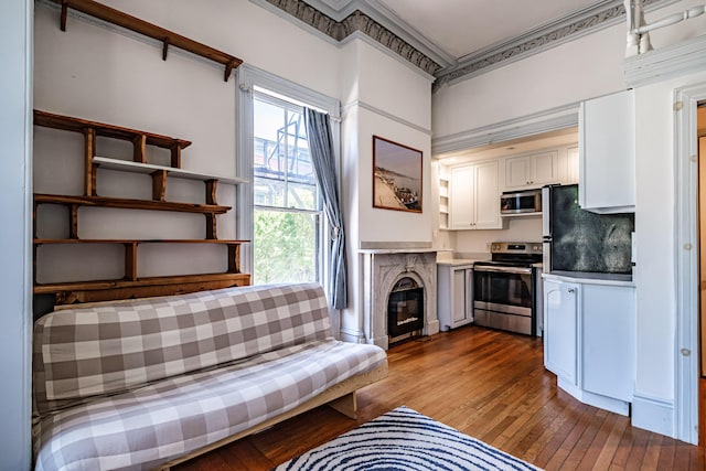 12 Deering St Unit 1, Portland, ME 04101 - living area with ornamental molding, hardwood / wood-style flooring, healthy amount of natural light, and a glass covered fireplace