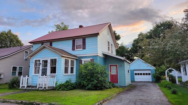 28 Eastland Ave, Millinocket, ME 04462 - view of front of property with an outbuilding, a garage, a chimney, driveway, and a metal roof