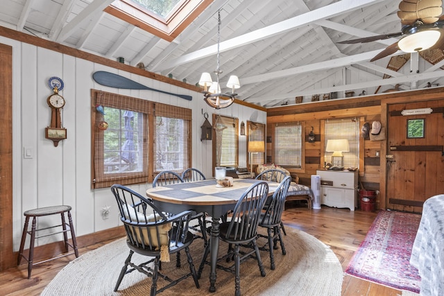 94 Crest Ave, Boothbay Harbor, ME 04538 - dining room with a skylight, wooden walls, wood-type flooring, beam ceiling, and a chandelier