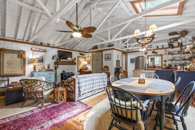 94 Crest Ave, Boothbay Harbor, ME 04538 - dining room featuring light wood-style floors, a chandelier, a tiled fireplace, beamed ceiling, and high vaulted ceiling