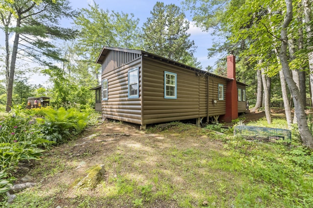 94 Crest Ave, Boothbay Harbor, ME 04538 - view of side of home with faux log siding, a chimney, and board and batten siding