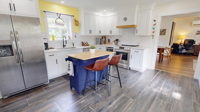 42 Hillside Rd, Orono, ME 04473 - kitchen with appliances with stainless steel finishes, white cabinets, recessed lighting, dark wood-style flooring, and a breakfast bar