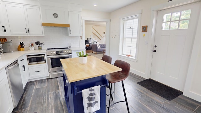 42 Hillside Rd, Orono, ME 04473 - kitchen featuring stainless steel appliances, a breakfast bar area, wood counters, dark wood-style flooring, and white cabinetry