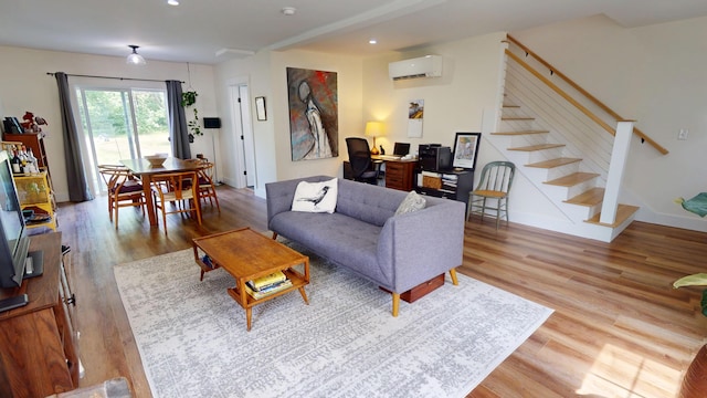 42 Hillside Rd, Orono, ME 04473 - living room with a wall mounted AC, wood finished floors, stairs, and recessed lighting