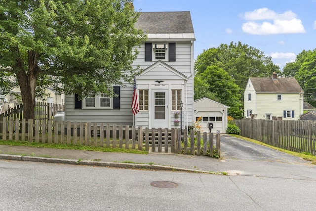 22 Cobb Rd, Bath, ME 04530 - view of front of home featuring a detached garage, roof with shingles, an outbuilding, driveway, and a fenced front yard