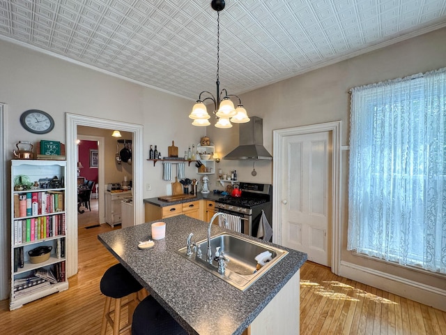 81 Parkview Ave, Bangor, ME 04401 - kitchen featuring wall chimney exhaust hood, stainless steel range with gas stovetop, dark countertops, light wood-type flooring, and an ornate ceiling