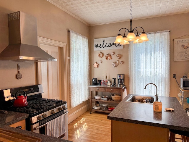 81 Parkview Ave, Bangor, ME 04401 - kitchen with stainless steel appliances, wall chimney exhaust hood, a chandelier, crown molding, and dark countertops